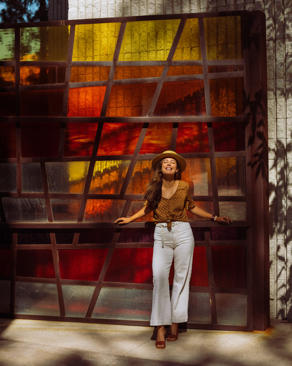 Rachel Off Duty: A Woman Smiling in Front of a Red, Orange, and Yellow Glass Art Piece
