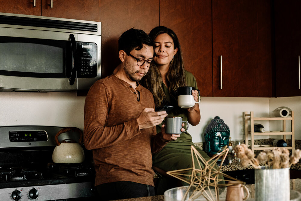 Rachel Off Duty: Man and Woman Drinking Coffee and Looking at Phone in Kitchen