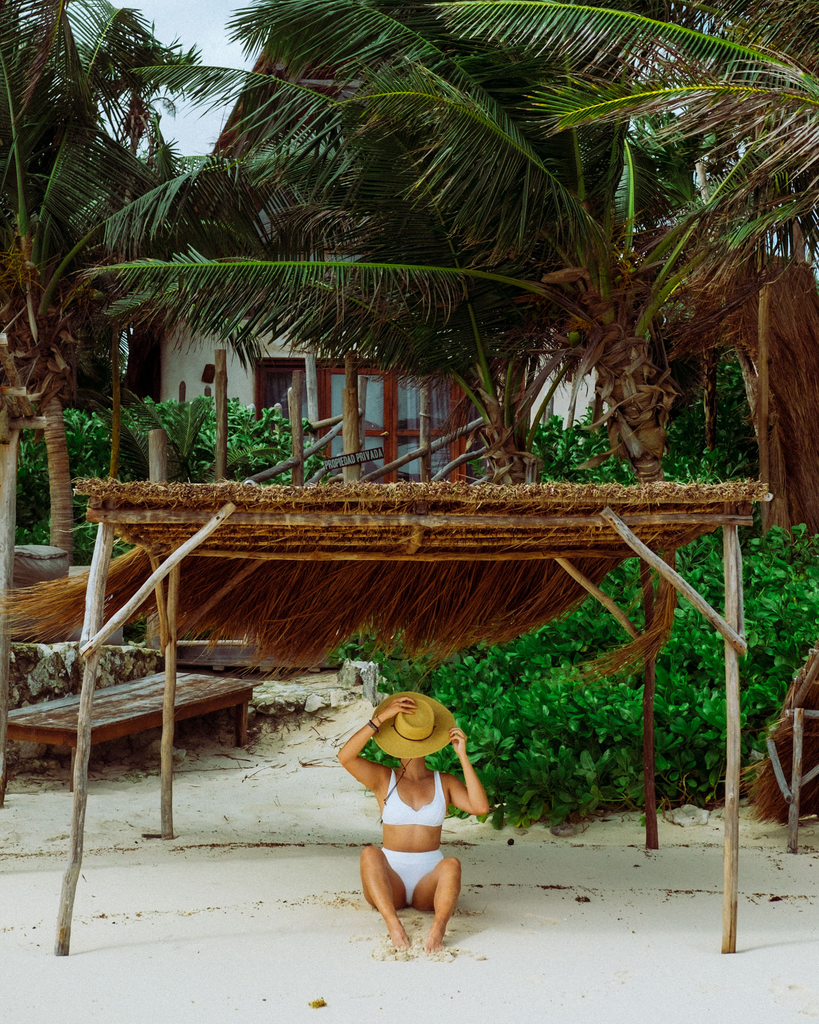 Rachel Off Duty: Woman in a White Swimsuit Sitting Under a Palapa in Tulum, Mexico