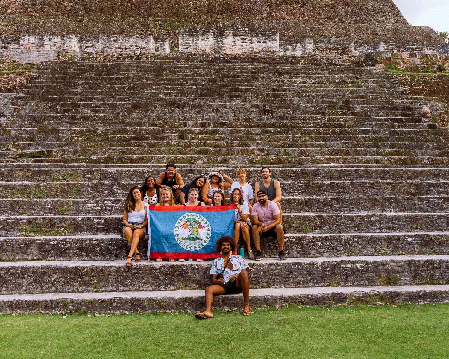 Rachel Off Duty: A Group of Travelers Posing with a Belize Flag at Xunantunich Mayan Ruins